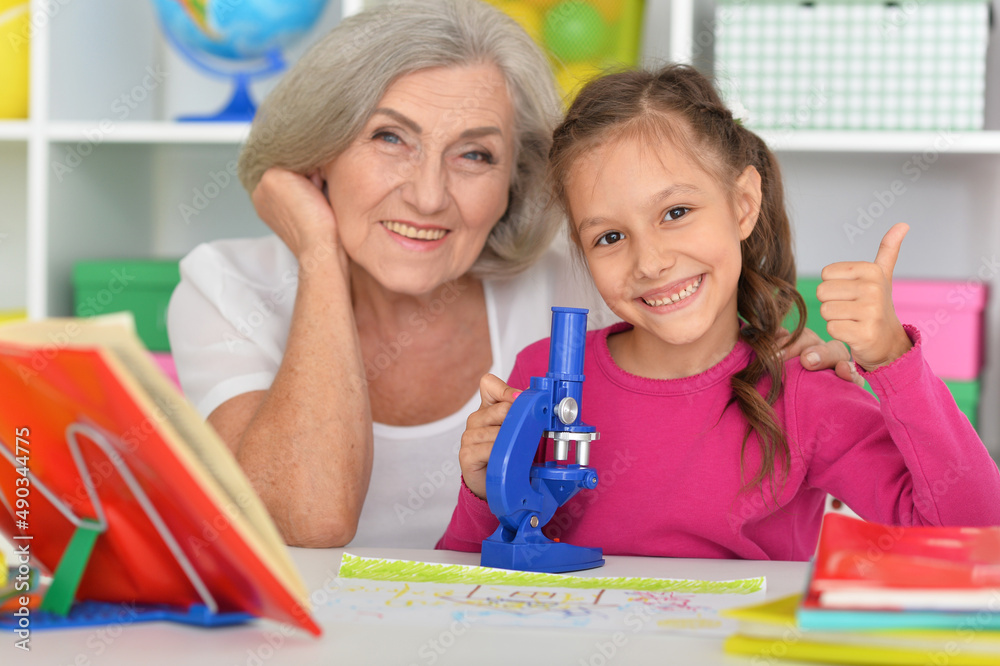 Girl doing homework with her grandmother at home Girl doing homework with her grandmother at home