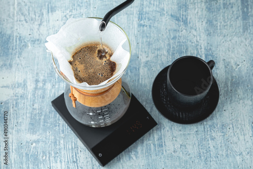Professional barista brews coffee using chemex. Alternative ways to brew coffee. Coffee shop concept. photo