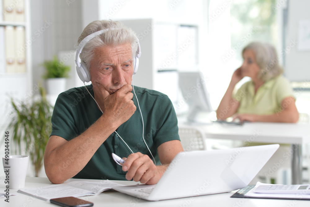 senior man using laptop in office senior man using laptop in office