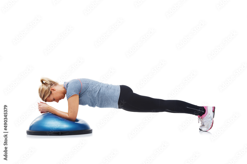 Shes getting into shape. A young woman working her upper body using a bosu-ball. Shes getting into shape. A young woman working her upper body using a bosu-ball.