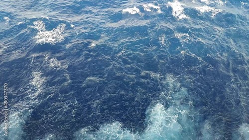 Tilt shot from a cruiser. First water by the side agitated by the propulsion and then view of the open sea and horizon on a birght but cloudy day. photo