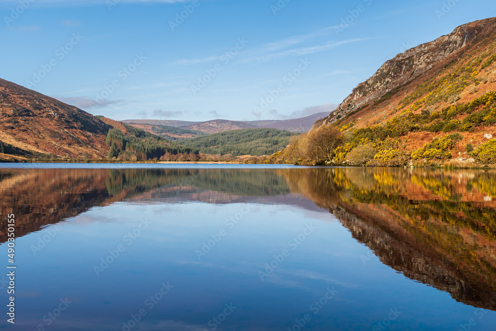 Stunning lake reflections landscape on a crisp and still spring morning at Lough Dan in the Wicklow Mountains in Ireland.