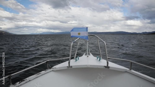 Argentinian flag flying in the prow of the ship navigating along the ocean in the Beagle Channel photo