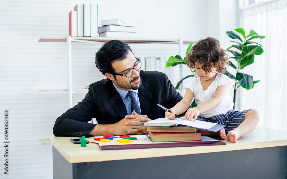 Caucasian handsome beard father wearing formal suit for working while taking care, playing together with love with little cute daughter at home or office. Family, New Normal and Lifestyle Concept. Caucasian handsome beard father wearing formal suit for working while taking care, playing together with love with little cute daughter at home or office. Family, New Normal and Lifestyle Concept.