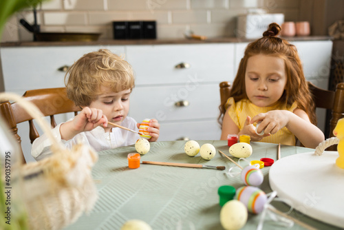 Cute kids getting ready for Easter. Children paint eggs before the holidays