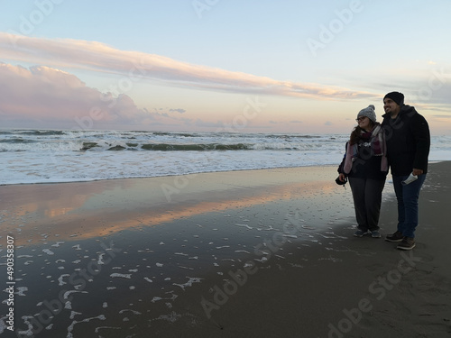 Smiling couple standing on beach in autumn, Marina di Ginosa, Ginosa, Taranto, Puglia, Italy