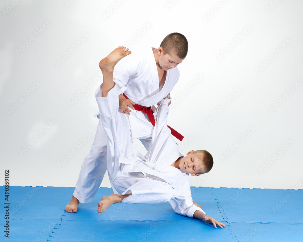 Children in judogi are training throws