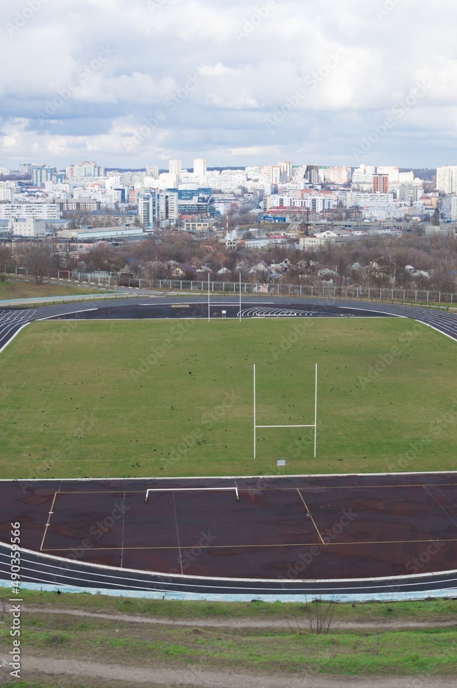 Empty oval sports stadium with running tracks and football field