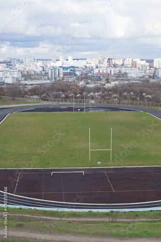 Empty oval sports stadium with running tracks and football field