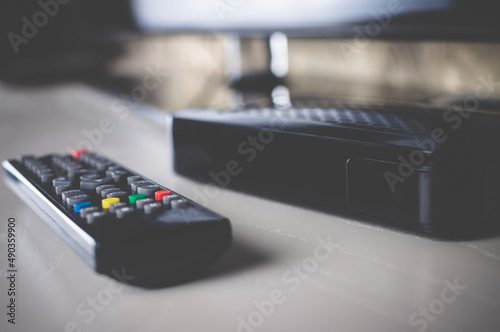 TV set-top box and all the necessary wires to connect it on a white background, selective focusing