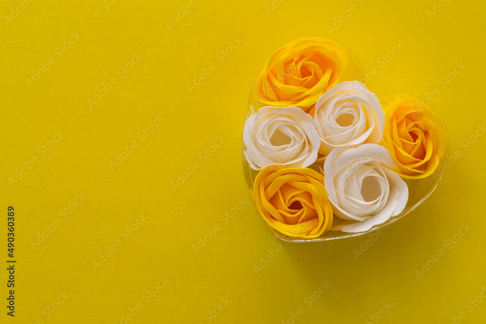 Gift box of soap in the form of white and yellow roses on a yellow background. Top view, space for text, copy space Gift box of soap in the form of white and yellow roses on a yellow background. Top view, space for text, copy space
