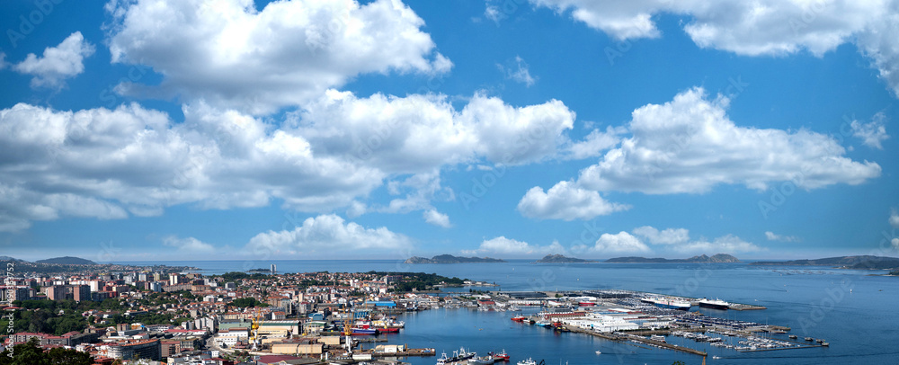 Panorámica de la ciudad de Vigo y su puerto, la Ría de Vigo y las Islas Cíes en un día de sol y nubes y cielo azul