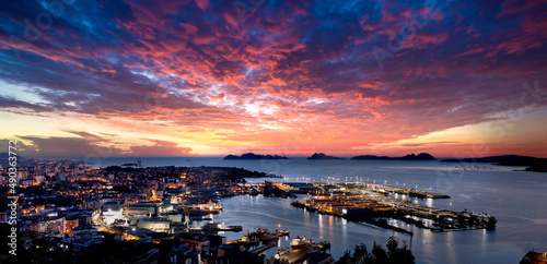 Vista general de Vigo al atardecer con la ciudad y el puerto y las Islas Cíes al fondo, con un increíble y espectacular cielo con nubes dramático y cálido