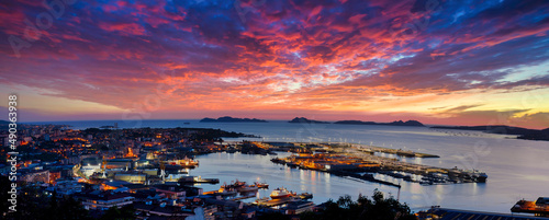 Vista general de Vigo al atardecer con la ciudad y el puerto en primer término y las Islas Cíes de fondo con un increíble cielo de nubes en tonos anaranjados photo