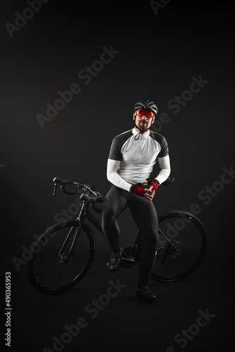 male cyclist with road bicycle on black background photo