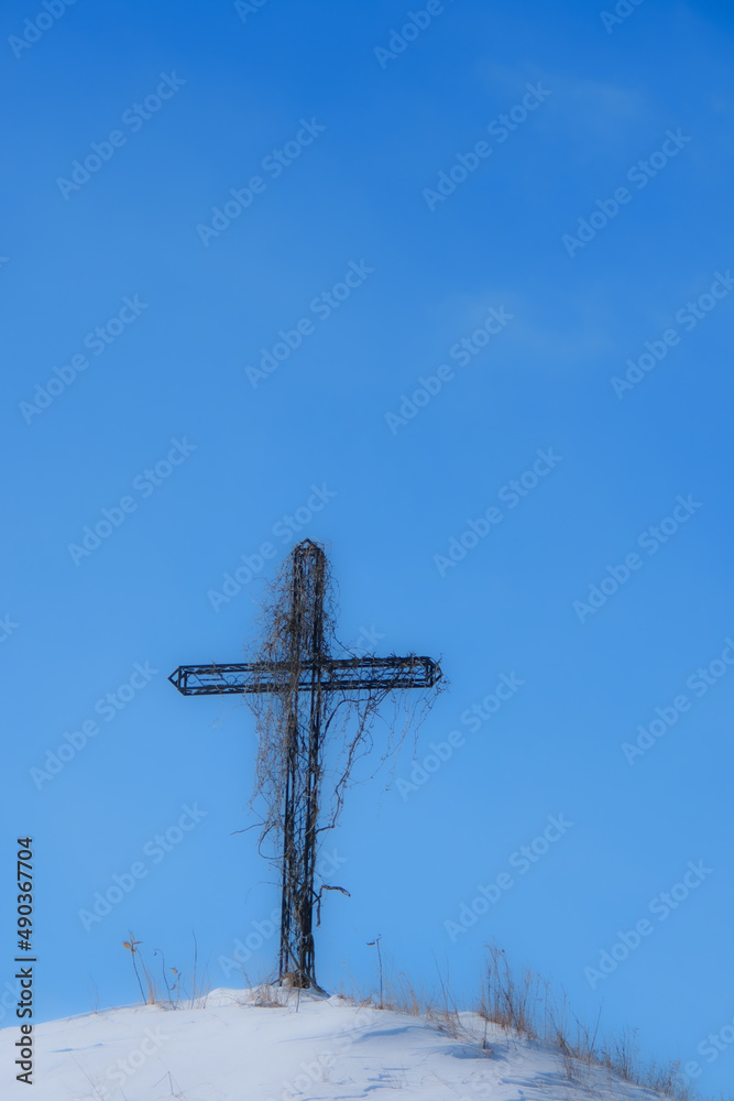Wayside cross on a snowy mound during the Canadian winter in Quebec