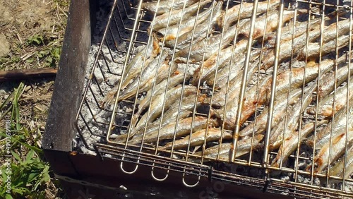 Close-up shot of cooking fish smelt on barbecue grill. Top view