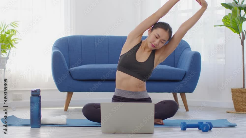 Asian Athlete woman stretching and exercise in exercise class video conference streaming online with friends in class at home.Happy healthy female warm up stretching muscle before workout exercise Asian Athlete woman stretching and exercise in exercise class video conference streaming online with friends in class at home.Happy healthy female warm up stretching muscle before workout exercise