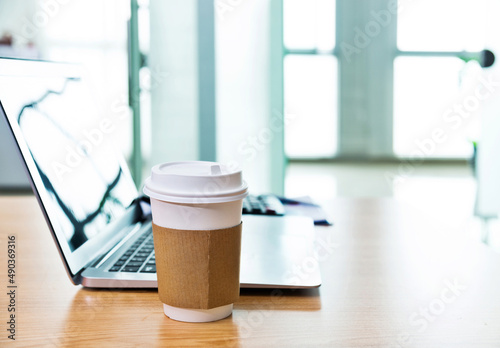 Laptop with coffee cup in office