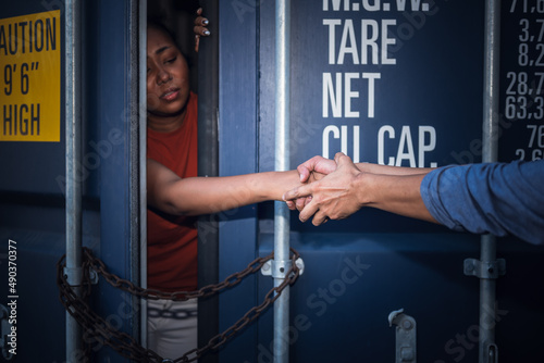 A person holding and helping to pull a several woman's hand which is inside a container, to human trafficking and illegal immigration concept.
