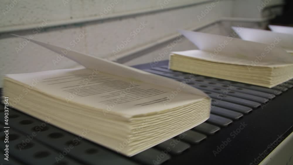 Brand New Books Fresh From Printer coming off of conveyer Belt At Publishing Factory