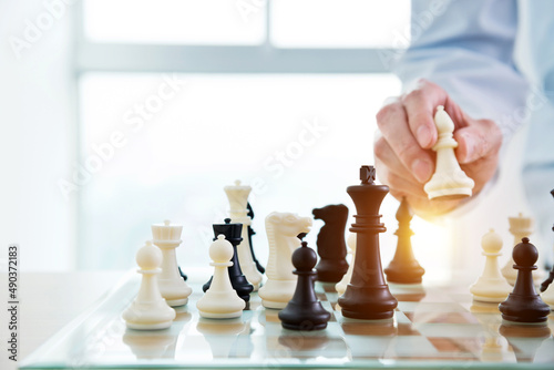 Businessman playing chess on board in office