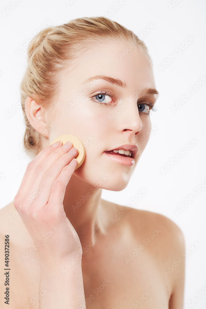 Quality foundation is the secret to a perfect appearance. Portrait of a blonde woman applying foundation. Quality foundation is the secret to a perfect appearance. Portrait of a blonde woman applying foundation.