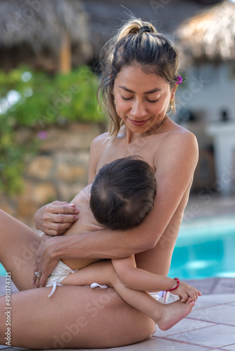 Portrait of a young latin mom breast feeding her baby boy photo