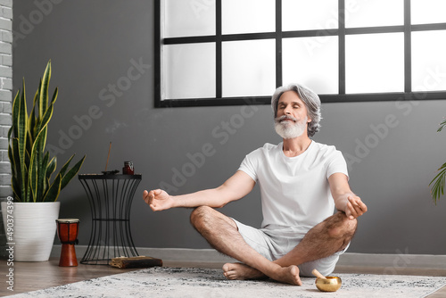 Mature man meditating at home