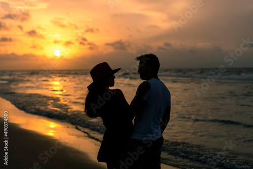 Young latin couple spending time at the beach at sunset