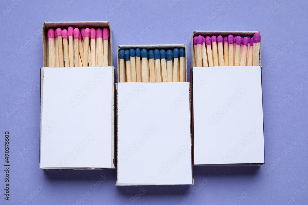Obraz premium Boxes with different new matchsticks on purple background
