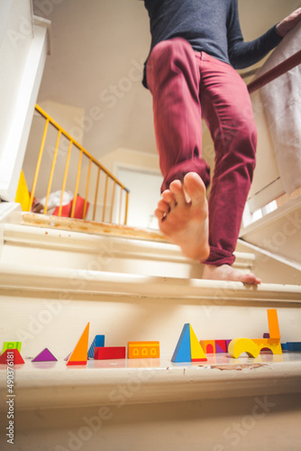 Fotografie Dad walking down staircase filled with children toys
