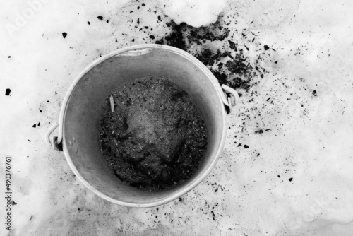 Metal bucket for ashes from the stove in the snow.