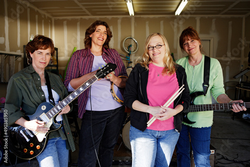 Portrait of Garage band composed of middle aged women, practicing in residential garage 