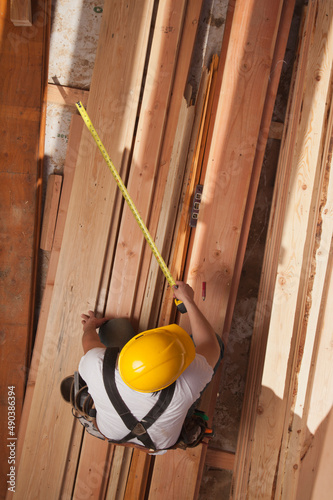 Aerial view of a man measuring wood on a residential construction site