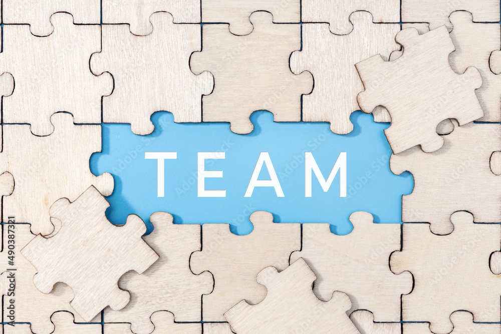 Team word on blue background surrounded by puzzle pieces Team word on blue background surrounded by puzzle pieces
