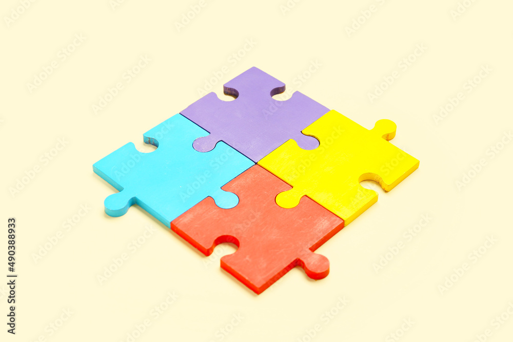 Colorful puzzle pieces on beige background. Concept of autistic disorder Colorful puzzle pieces on beige background. Concept of autistic disorder