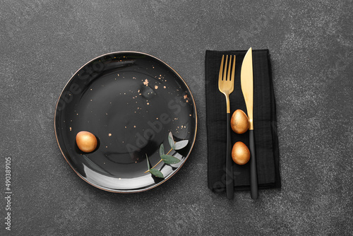 Table setting with Easter eggs and eucalyptus branch on dark background © Pixel-Shot