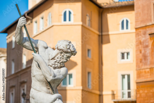 Neptune Statue Against an Old House on Piazza Navona in Rome, Italy. photo