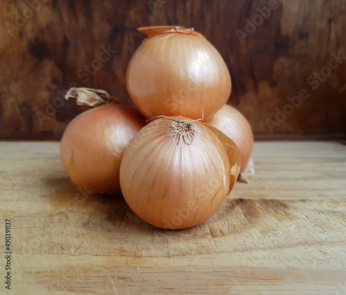 three onions arranged on a chopping board