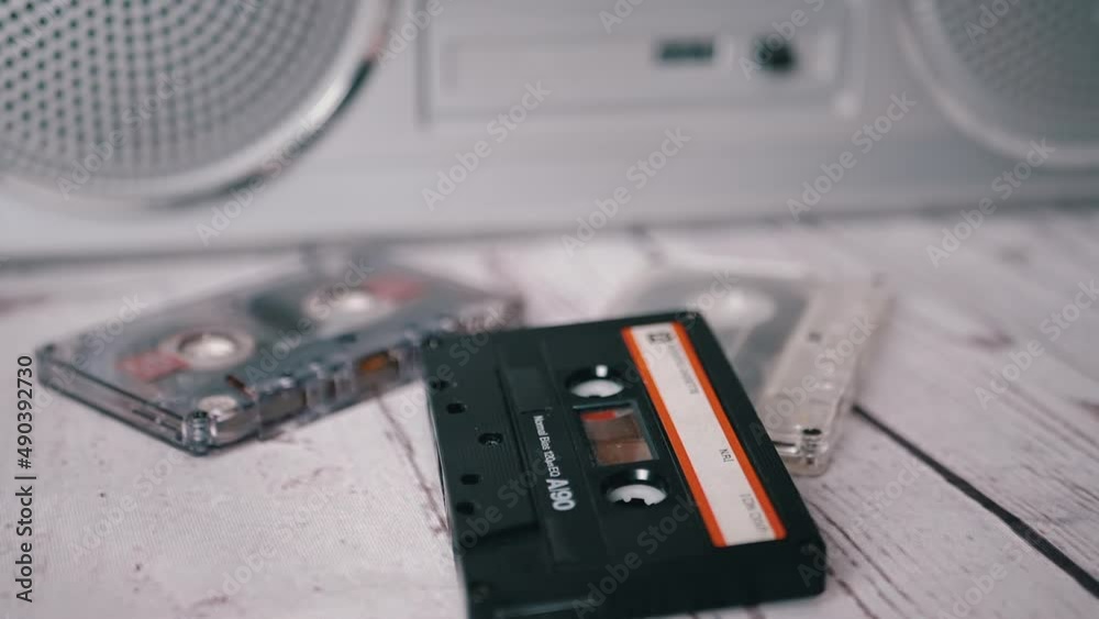 Video Stock Female Hands Throwing an Old Black Audio Cassette on Table