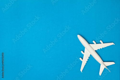 Airplane model. White plane on blue background. Travel vacation concept. Summer background. Flat lay, top view, copy space.
