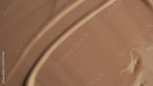 Foundation close-up, sliding cosmetic brush. Texture of foundation close-up. Advertising of decorative cosmetics. Beige paint. photo