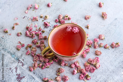 Rose buds tea in a pink cup .
Tea made from tea rose petals