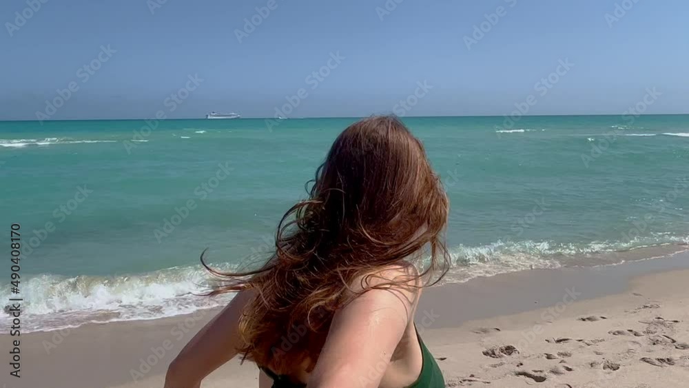 Young woman pulls her boyfriend over the beach into the sea - travel photography Young woman pulls her boyfriend over the beach into the sea - travel photography