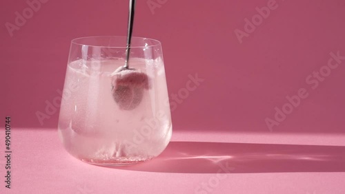 Stirring collagen in a glass of water with a spoon. Skin care. Slow motion.
