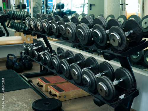 Rows of dumbbells in the gym. Rack with heavy dumbbells in a fitness club. Workout bodybuilding concept.