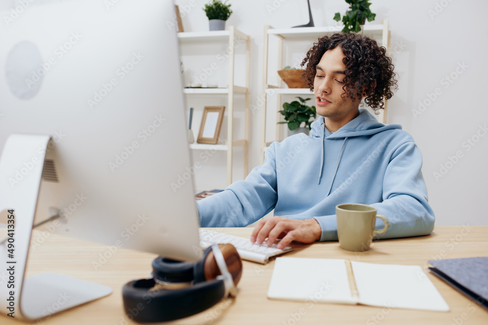 handsome guy sitting at a table in front of a computer freelance Lifestyle