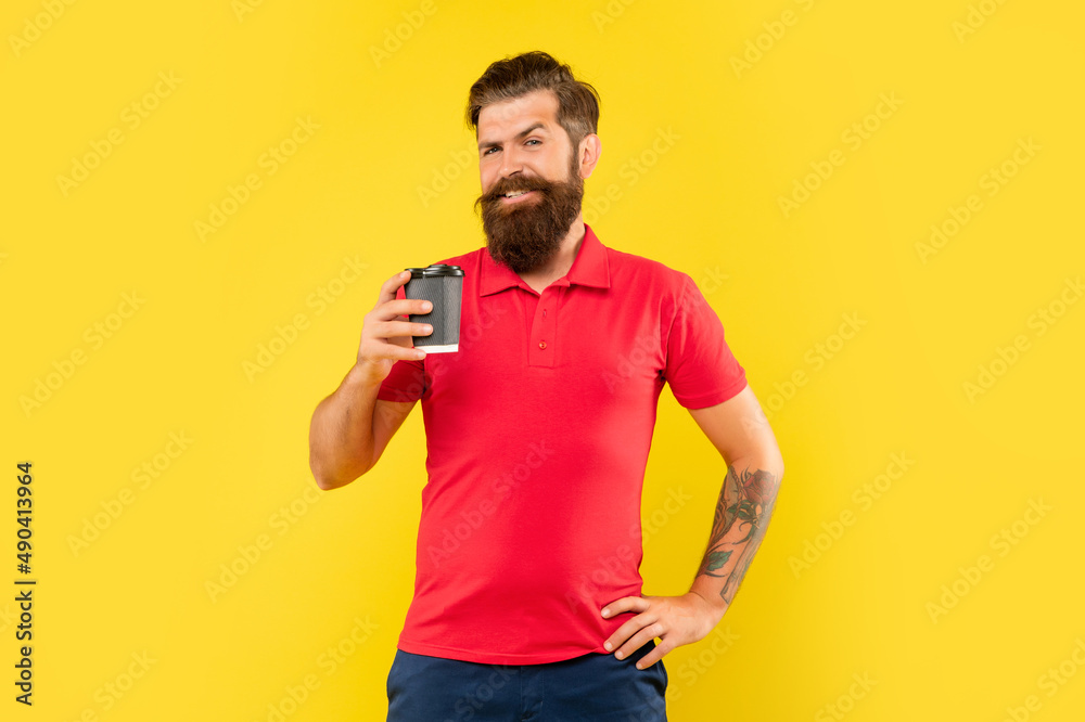 Happy man in casual tshirt holding disposable cup with arm akimbo yellow background, takeaway coffee Happy man in casual tshirt holding disposable cup with arm akimbo yellow background, takeaway coffee