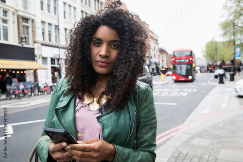 Woman walking the streets of London using mobile phone photo